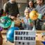 Birthday celebration with friends gathered around a cake and gifts